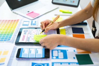 UX grafik tasarımcı elleri web akıllı telefonu için uygulama süreci prototip kablo grafiği planlamak için tablet kullanıyor