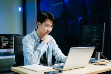 Asyalı yazılım geliştirici ekranlarda, tablette ve telefonda geç saatlere kadar çalışıyor. Programlama kavramı, ofisteki teknoloji yaşam tarzı