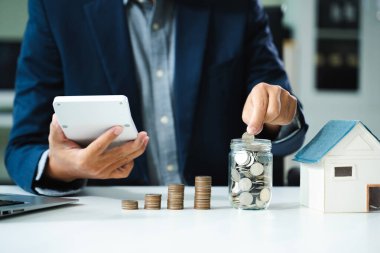 işadamı kavramı finans muhasebe için para tasarrufu hesaplamak için smartphone ve hesap makinesi kullanma ile cam koyarak paralar holding