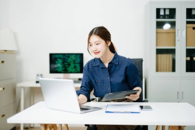 Tablet ve ekran görüntüleme kodlarıyla çalışan genç bir kadın programcı. Modern teknoloji ofis kurulumu, yazılım, kodlama, bilişim ve teknoloji stoku fotoğraf temaları için harika