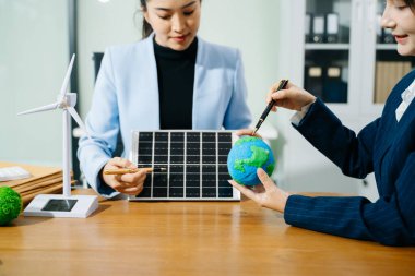 İki kadın ekolojik dünya modellerini, güneş panellerini ve yenilenebilir enerji çözümlerini planlamak için akıllı bir evi analiz ediyor. 
