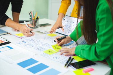 Mobil bir uygulama için UX / UI kablo tasarımı üzerinde çalışan yaratıcı ekip. Modern bir ofiste web sitesi arayüzü geliştirme için planlama, çizim ve takım çalışması.