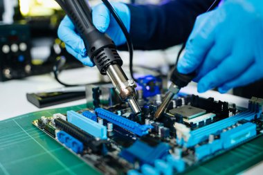 Teknisyen laboratuardaki ana kartı fotokopi aletiyle onarıyor. bilgisayar donanımı, cep telefonu, elektronik ve onarım kavramı.