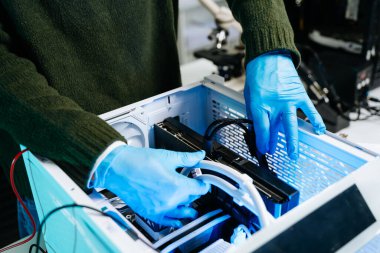 Teknisyen eldiven giyerek özel bilgisayar yapımına GPU yüklüyor. Modern çalışma alanında bilgisayar onarımı, donanım montajı, mühendislik ve teknoloji bakımı kavramı.