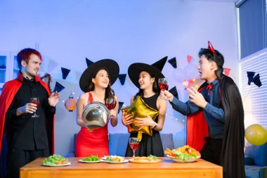 Neşeli ofis Cadılar Bayramı partisi kostüm giymiş iş arkadaşlarıyla, içkiler ve kahkahalarla kutlama, takım çalışmasını teşvik etme ve şenlik ruhu.