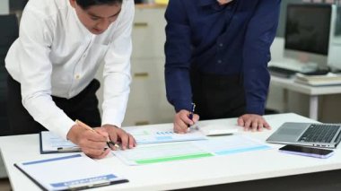 Modern ofiste mali belgelerle çalışan iki işadamı.