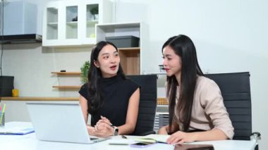 Çağdaş bir çalışma alanında otururken stratejik iş büyümesini tartışan profesyonel pazarlama ekibi üyeleri.