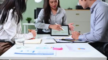 Bir tablet üzerindeki veriler üzerinde işbirliği yapan bir grup iş adamı