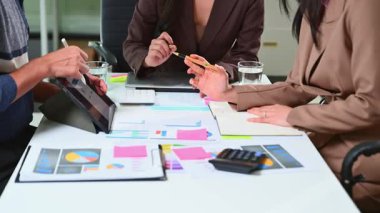 Ofisteki dijital tablette finansal veri ve grafikleri gösteren profesyonel bir ekip