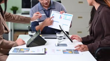 Ofisteki dijital tablette finansal veri ve grafikleri gösteren profesyonel bir ekip