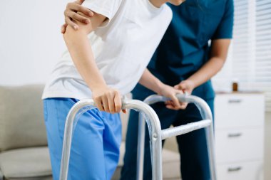 Fizik tedavi sırasında Walker 'ı kullanan hastaya yakından bakın. Profesyonel sağlık desteği, iyileşme, rehabilitasyon ve hareket eğitimi göstermektedir..