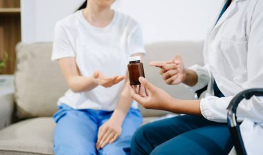 Danışmanlık sırasında hastayla ilaçları tartışan, klinik tedavide güven, bakım ve tıbbi iletişimi gösteren sağlık uzmanları.