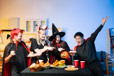 Cadılar Bayramı kostümlü bir grup genç arkadaş kapalı bir partide yemek ve içkinin tadını çıkarıyorlar. Gerçek insanlar eğlence, ürkütücü titreşimler, kırmızı bardaklar ve balkabağı dekoru ile kutluyor..