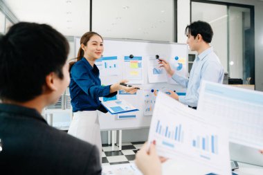 Başarılı bir toplantının ardından gülümseyen Asyalı iş adamları, modern ofis ortamında ortaklığı, takım çalışmasını ve şirket başarısını sembolize ediyor..