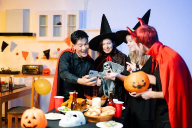 Cadılar Bayramı partisi, balkabağı ve hayalet iskelet gibi ürkütücü aksesuarlara sürpriz ve kahkahalarla tepki verir. Mükemmel mevsimlik eğlence, dekor ve şenlik havası..