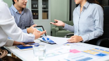 Takım işi toplantısı sunumu. Modern ofiste el işi projesi. Dizüstü bilgisayar, tablet ve akıllı telefon beyaz masada.