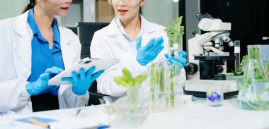 Laboratuvar önlüklü gıda bilimcileri, numuneleri test ediyorlar ve modern bir laboratuvar ortamında gıda güvenliğini ve kalitesini analiz ediyorlar..