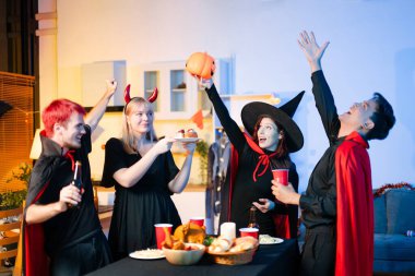 Cadılar Bayramı kostümlü bir grup genç arkadaş kapalı bir partide yemek ve içkinin tadını çıkarıyorlar. Gerçek insanlar eğlence, ürkütücü titreşimler, kırmızı bardaklar ve balkabağı dekoru ile kutluyor..