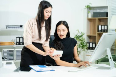 İş kadını takım toplantısını yönetiyor ve birlikte çalışma ofisinde mali durumuyla birlikte tablet ve dizüstü bilgisayar kullanıyor