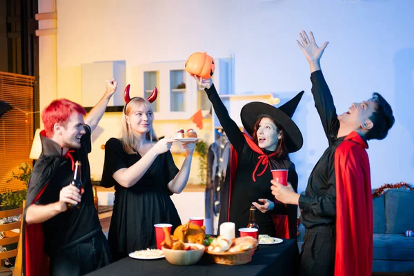 Cadılar Bayramı kostümlü bir grup genç arkadaş kapalı bir partide yemek ve içkinin tadını çıkarıyorlar. Gerçek insanlar eğlence, ürkütücü titreşimler, kırmızı bardaklar ve balkabağı dekoru ile kutluyor..