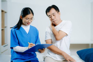 Genç bayan hemşire yaşlı bir adama boyun ağrısı için yardım ediyor. Sağlık, ağrı yönetimi, fizyoterapi, hemşirelik ve kıdemli tıbbi danışmanlık konuları için ideal.