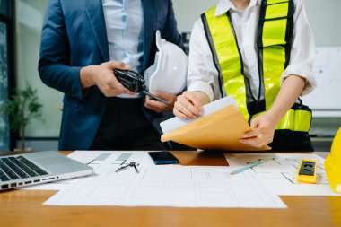 Modern ofisteki inşaat sahasında mimari projeyle büyük çizimlere yansıyan yaratıcı mimar