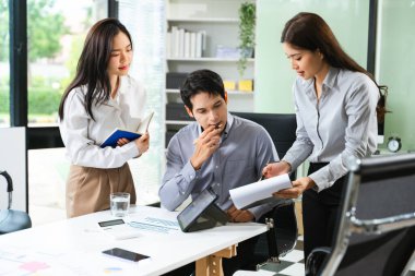 Modern ofiste takım planlaması ve tartışması için tablet ve not defterlerini kullanan genç iş adamları. Girişim, takım çalışması, gerçek insanlar, verimlilik
