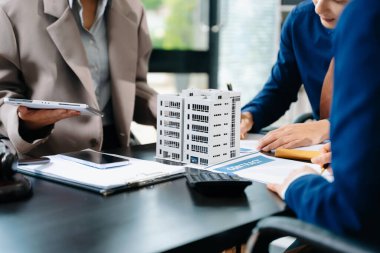 Modellik, sözleşme ve hesap makinesiyle emlak anlaşmasında iş ekibi danışmanlığı yapıyor. Emlak yatırımı, yasal anlaşma ve finans konuları için ideal.