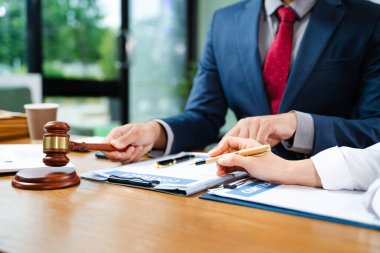 Avukat ve müvekkil ile hukuki istişarenin kapanması tokmağın yanında sözleşme imzalaması. Hukuk, adalet, iş anlaşması, anlaşma, gerçek insanlar, yasal evraklar..