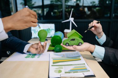 Çalışma teknolojisi ve iş dünyası ağı sıfır ve karbon nötr konsepti için el bilgisayarı kullanmayı planlayan iş adamları. NET Sıfır simgeleri ve sembolleri eko dünyasını kurtarır ve kirliliği azaltır. yeşil enerji