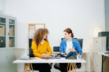 Modern ofisteki UX UI tasarımcıları uygulama kabloları, renk paletleri ve dijital araçlar üzerinde çalışıyorlar. Yaratıcı takım çalışması, planlama, teknoloji ve arayüz tasarımı.