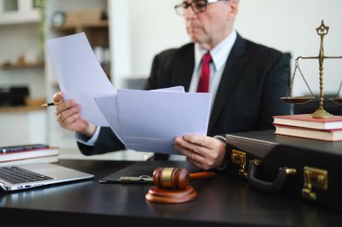 Adalet ve hukuk kavramı. Beyaz masadaki bir mahkeme salonunda erkek yargıç ve ofiste çalışan avukat veya erkek avukat..