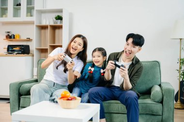 Mutlu Asyalı ebeveynler ve çocuklar arasında bağ kurulması, oyunlar oynaması, gülmesi ve sosyal medyanın tadını çıkarması. Aile zamanı, aşk, neşe ve modern yaşam tarzı..