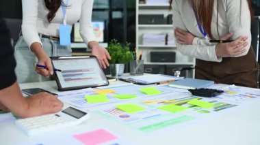 Yüksek teknolojili bir şirket ortamında mali belgeleri ve gelir grafiklerini inceleyen genç meslektaşların yakın çekimleri