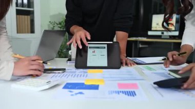 Karmaşık mali tablolar ve veri görselleştirmelerini yorumlayan genç profesyonellerin yer aldığı stratejik gözden geçirme oturumu