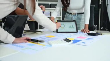 Genç fintech uzmanları dijital ekranda gerçek zamanlı pazar verilerini ve performans grafiklerini analiz ediyorlar.