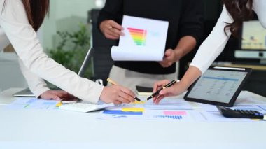 Modern ofis içi mali verileri inceleyen bir grup genç profesyonel.