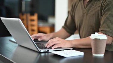 Ofisteki bir masada dizüstü bilgisayarda yazı yazan bir gencin profil görüntüsü