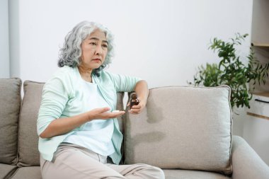 Evde ilaç tutan bunalımlı yaşlı kadın. Odada yaşlı akıl sağlığı, yalnızlık, endişe, üzüntü ve sağlık konsepti.