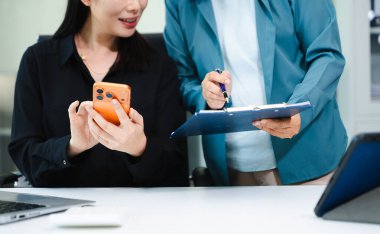 Asyalı iş kadınları modern ofiste başarıyı kutluyorlar. Dizüstü bilgisayarla takım çalışması, liderlik, akıl hocalığı ve işbirliği