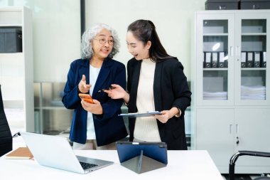 Nazik yönetici yönetici, Asyalı bayan pazarlama müdürüyle iş çözümlerini paylaşır ve tartışır.