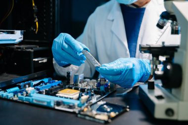 Yenilikçi bir proje kapsamında mikroçipin detaylı onarımına odaklanan profesyonel Asyalı donanım mühendisi.