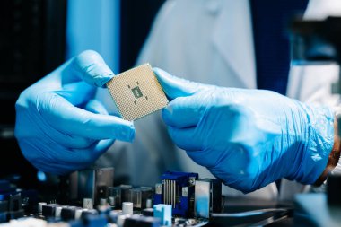 Orta yaşlı erkek teknisyen devre kartındaki karmaşık donanım sorunlarını çözmek için mühendislik uzmanlığını kullanıyor..