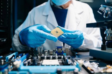 Orta yaşlı erkek teknisyen devre kartındaki karmaşık donanım sorunlarını çözmek için mühendislik uzmanlığını kullanıyor..