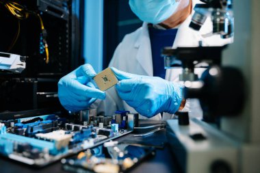 Kendini adamış bir donanım mühendisi, potansiyel teknik arızaları tespit etmek için parlak laboratuvar ışıkları altında bir anakart inceliyor..