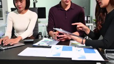 İş adamları büyüme grafiklerini ve finansal verileri titizlikle analiz ederken, araştırma amaçlı dijital tablet kullanıyorlar.