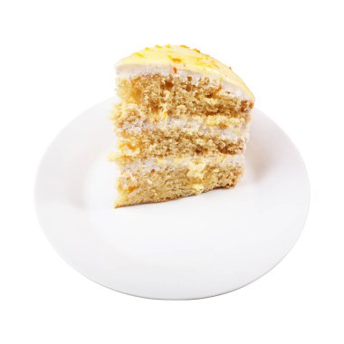 Beyaz arka planda izole edilmiş beyaz bir tabakta portakal kabuğu talaşlarıyla süslenmiş sarı jöleli bir bisküvi kremalı pasta.