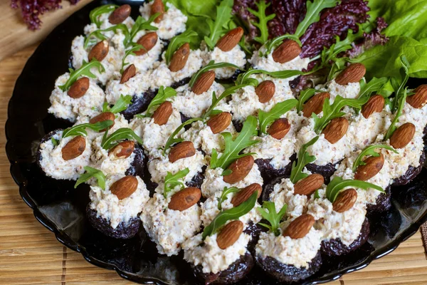 Glazed prunes with cheese, almond and rocket - appetizer