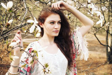 Genç güzel kadın çiçek açan Manolya bahçede poz model.
