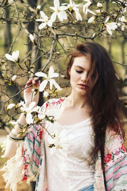 Genç güzel kadın çiçek açan Manolya bahçede poz model.